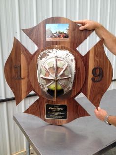 a man pointing at a plaque on top of a table with a clock in it