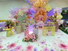 a table topped with lots of pink and purple flowers next to a giant princess doll