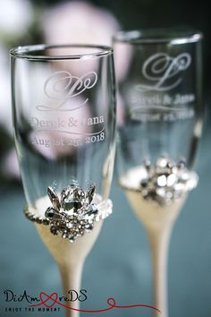 two wine glasses with diamond decorations on them are sitting side by side in front of each other