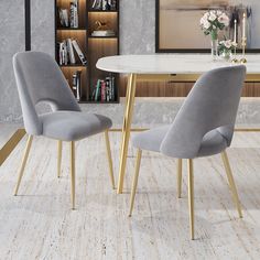 two grey chairs sitting in front of a white table