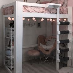 a loft bed with pink walls and white furniture in a room that looks like a child's bedroom