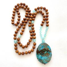 Tranquility Mala Beads - Ocean Jasper & Sandalwood Beads - Hand Knotted - 108 Bead Mala - Length approx. 40" The rhythmic cadence of the sea has always called humanity to its shores.  This Ocean Jasper and Sandalwood Mala bead necklace from True Nature Jewelry brings that same spirit of peace and letting go.  Hand knotted for flexibility and beauty, it features soothing and fragrant Sandalwood beads and Light Aqua Agate to help balance the emotions.  A large Ocean Jasper pendant which brings pea Turquoise Spiritual Beads For Meditation, Spiritual Turquoise Beads For Meditation, Spiritual Beaded Necklaces With Oval Beads For Beach, Nature-inspired Beaded Necklaces With Natural Stones, Nature-inspired Beaded Necklaces With Round Natural Stones, Artisan Wooden Beads For Meditation, Artisan Wooden Meditation Beads, Hand-strung Nature-inspired Beaded Necklaces, Nature-inspired Beaded Necklace With Wooden Beads