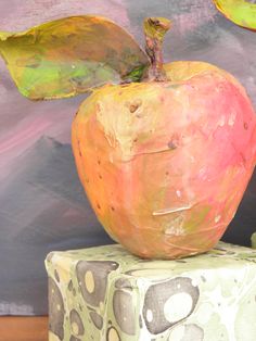 an apple sitting on top of a green block