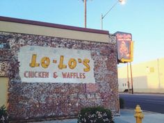 a sign on the side of a building that says lo - lo's chicken and waffles