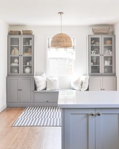 a kitchen with gray cabinets and white counter tops