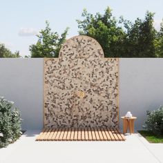 an artisticly designed outdoor shower in the middle of a garden