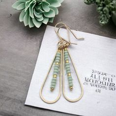 Add a touch of fun and femininity with our Harley gold teardrop earrings, adorned with delicate mint green seed beads. Perfect for any occasion (and any outfit), these long earrings will complete your look and add a hint of whimsy to your style. A must-have for any accessory lover! Approximately 2.25” long Made with 14k Gold Filled Light Mint Green Seed Beads Polished to a high shine Handmade in Montana Sent in a ribboned gift box with polishing cloth Elegant Nickel-free Brass Beaded Earrings, Nickel-free Teardrop Beaded Brass Earrings, Turquoise Beaded Brass Earrings, Bohemian Turquoise Beaded Brass Earrings, Mint Green Earrings, Light Mint Green, African Turquoise, Jewelry Packaging, Long Earrings