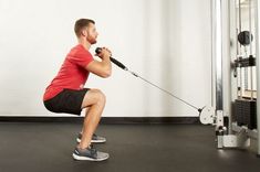 a man is squatting with a pull rope