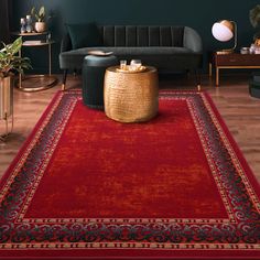 a living room with green walls and a red rug on the floor next to a couch