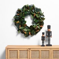 a nutcracker figurine is standing next to a wreath on a wall