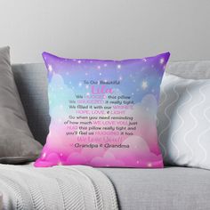 a pink and blue throw pillow sitting on top of a couch with a poem written in it