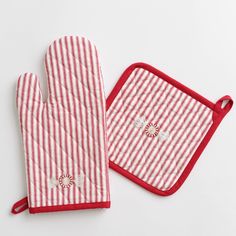 two oven mitts are sitting next to each other on a white surface, one has a red and white striped oven mitt