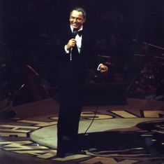 a man in a tuxedo standing on stage