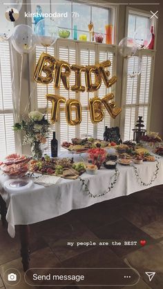 a table topped with lots of food and balloons