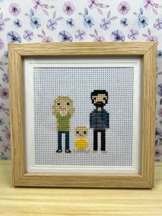 a cross stitch picture with two people holding hands