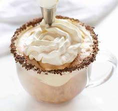 a cup filled with whipped cream and chocolate sprinkles on top of it