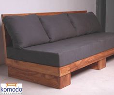 a couch made out of wood with pillows on it