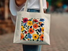 Add a splash of color to your daily errands with this colorful floral tote bag. Featuring a vibrant flower pattern, this reusable grocery bag is perfect for shopping, trips to the beach, or casual outings. Its eco-friendly design and bold flower print make it an eye-catching accessory that combines style and practicality. Product Features: Fabric: 100% Cotton Canvas | Heavy fabric (12 oz/yd² (406.9 g/m Handles: Self-fabric handles with reinforced stitching Size: 15"x16" Inches Multicolor Rectangular Canvas Bag With Floral Print, Multicolor Floral Print Tote Canvas Bag, Multicolor Floral Print Canvas Tote Bag, White Floral Print Bags As Gifts, White Floral Print Canvas Tote Bag, White Eco-friendly Flower-shaped Canvas Bag, Eco-friendly White Flower-shaped Canvas Bag, Everyday White Floral Print Canvas Bag, White Floral Print Canvas Bag For Everyday Use