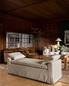 a living room filled with furniture and wooden walls