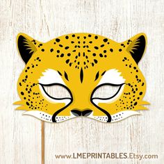 a yellow and black leopard mask with eyes closed on top of a wooden board background