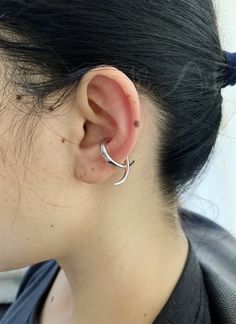 a close up of a person wearing a pair of ear piercings in their ears