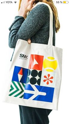 a woman is holding a shopping bag and talking on her cell phone while standing in front of a white background