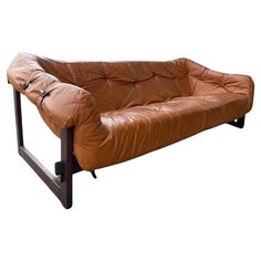 a brown leather couch sitting on top of a metal frame