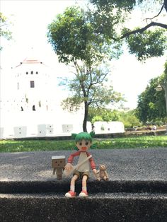 a small doll sitting on top of a cement step