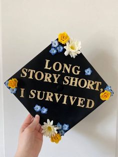 a graduation cap that says long story short, i survived with flowers on the front