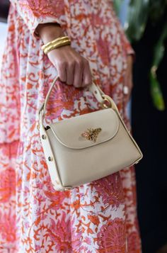 The Nina Handbag is the "go anywhere" bag that will elevate your style in an instant. It holds all the essentials and comes with a top handle and a crossbody gold chain strap. Nina is also compatible with any of our fashion straps (sold separately). Shown here with our Tortoise Resin Crossbody Chain Also shown with our navy/red scarf chain with the Red/Ivory stripe dress. Pebbled leather Top handle (drop is 4.5") Comes with an additional chain strap for crossbody carrying Flap closure with butte Red Scarf, Store Hours, Shoulder Chain, Red Scarves, Stripe Dress, Hand Bag, Leather Top, Chain Strap, Pebbled Leather