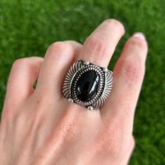 This ring needs no introduction, except maybe a big "WOW!" A perfectly hand-crafted unique ultra-heavy gauge ring that accents bold silverwork and soldered flare embellishments.  Created completely with sterling silver centered around a high shine black onyx cabochon. Navajo silversmith Delbert Gordon shows off his famous flare detail in this stand-out, bold showstopping piece. Size US 11 (Ring resizing is available for a $30 fee). Weighs 22.3 grams. Face of ring is 1" tall, back of ring is 3/8" at the smallest point Stone measures 11x16mm Black Southwestern Jewelry With Turquoise Accents, Black Southwestern Concho Jewelry, Southwestern Black Concho Jewelry, Ring Handmade, Black Onyx, Handmade Ring, Statement Rings, Onyx, Embellishments