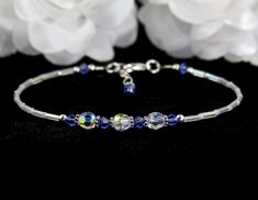 Something blue for the bride to wear on their wedding day. Enjoy this lovely, handmade blue wedding anklet. This custom wedding anklet is created with glistening clear rainbow clear and pearl seed beads, sapphire (aqua, light sapphire, sapphire, dark sapphire) Swarovski Austrian bicone crystals, perfectly round Swarovski beads, Bali .925 silver, and sterling silver. Accent Colors: Aqua, Sapphire (shown), Light Sapphire, Dark Sapphire Main Crystal Color: Crystal AB Anklet band: Rainbow clear and Elegant Blue Anklets For Gifts, Elegant Blue Anklets For Gift, Adjustable Sapphire Bracelets For Wedding, Adjustable Blue Crystal Bracelet For Anniversary, Adjustable Blue Crystal Bracelet For Wedding, Handmade Elegant Anklets For Wedding, Adjustable Blue Beaded Bracelets For Wedding, Handmade Blue Crystal Wedding Bracelet, Something Blue For Bride