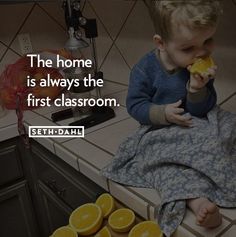 a little boy sitting on top of a kitchen counter eating an orange slice with the caption, the home is always the first classroom