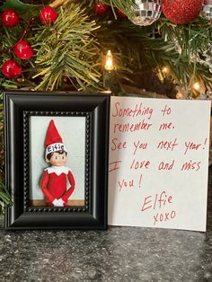 an elf's message is posted next to a christmas tree