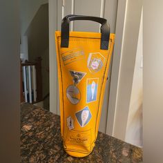 a yellow bag with stickers on it sitting on a counter