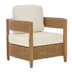 a wicker chair with white cushions on it