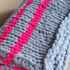 two crocheted blankets folded on top of each other with pink and gray designs