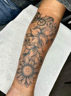 a woman's arm with flowers and butterflies on it