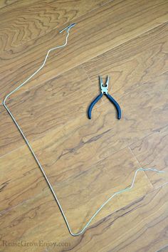 a pair of pliers sitting on top of a hard wood floor next to wire