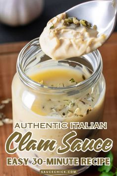 a spoon full of cheese sauce sitting on top of a wooden cutting board next to a jar