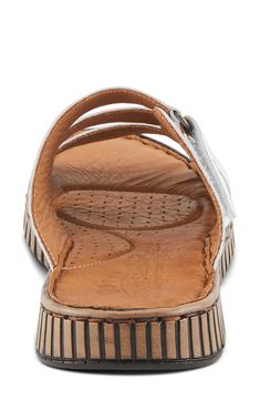 An adjustable instep strap offers a customized fit on a leather slide sandal grounded by a cushioned footbed for lasting comfort. 1" heel Adjustable strap with hook-and-loop closure Cushioned footbed Leather upper and lining/synthetic sole Made in Turkey Comfortable Slides With Adjustable Strap And Round Toe, Adjustable Strap Slip-on Footbed Sandals, Adjustable Slides With Leather Footbed, Adjustable Leather Footbed Slides, Comfortable Adjustable Leather Slides, Adjustable Leather Slip-on Slides, Adjustable Comfortable Leather Slides, Adjustable Double Strap Leather Slides, Comfortable Slide Sandals With Adjustable Strap