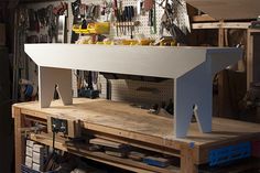 a workbench with tools hanging on the wall