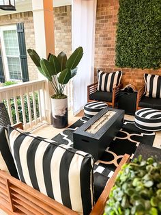 a black and white striped couch sitting on top of a wooden table next to a potted plant