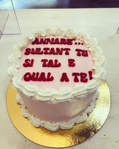 a cake that is sitting on top of a table with writing on the frosting