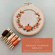 an orange pumpkin wreath is on the wall next to some spools of thread