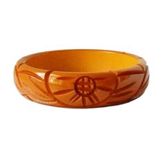 "Item: This is a lovely bakelite bangle bracelet carved with flowers and leaves on either side. It was made in the late 1930s and has a very deep yellow / orange color. It's in excellent condition, has been tested and guaranteed vintage bakelite. Be sure to check our other listings for lots more bakelite jewelry! Measurements: 3/4\" wide - 2 1/2\" inner diameter, 3\" outer diameter, 7 3/4\" inner circumference. Condition: 9.5 - Excellent Shipping: U.S shipping is $5.00 for USPS First Class Mail Retro Bakelite Jewelry As Gift, Vintage Bakelite Bangle Jewelry, Vintage Bakelite Bangle, Vintage Carved Orange Jewelry, Orange Carved Vintage Jewelry, Vintage Orange Carved Jewelry, Vintage Bakelite Bracelet, Retro Bakelite Jewelry, Retro Round Bakelite Jewelry