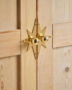 the door handle is gold and has four balls on it, as well as two stars