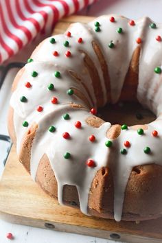 a bundt cake with icing and sprinkles on a cutting board