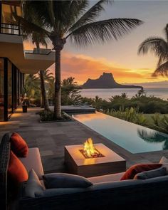 a fire pit in the middle of a patio next to a large body of water