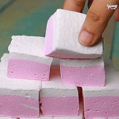 someone is placing marshmallows on top of each other